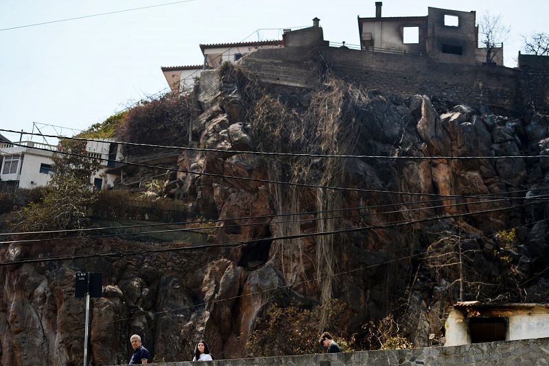 Ciudadanos caminan entre las casas arrasadas por las llamas