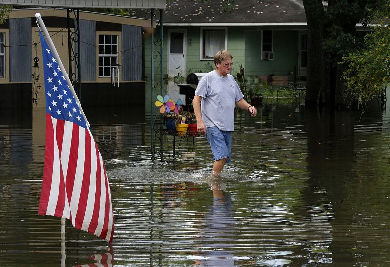 David Landaiche, un vecino de Sorrento, en Luisiana, camina por el río en que se ha convertido su calle debido a las fuertes lluvias.