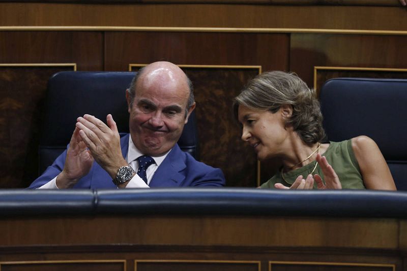 Los ministros en funciones de Economía, Luis de Guindos, y Agricultura y Pesca, Isabel García Tejerina, aplauden durante el discurso de investidura del presidente del Gobierno en funciones, Mariano Rajoy.