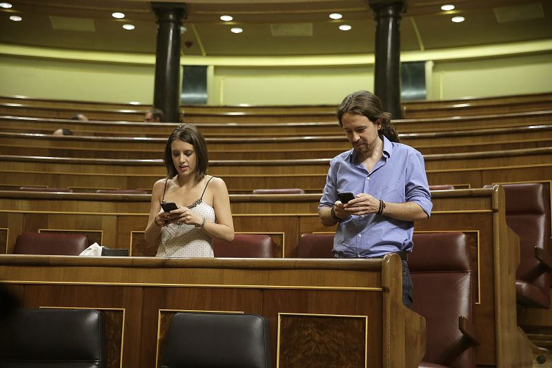 El líder de Podemos, Pablo Iglesias, y su jefa de gabinete, Irene Montero, ocupan sus escaños al inicio de la segunda sesión del debate de investidura