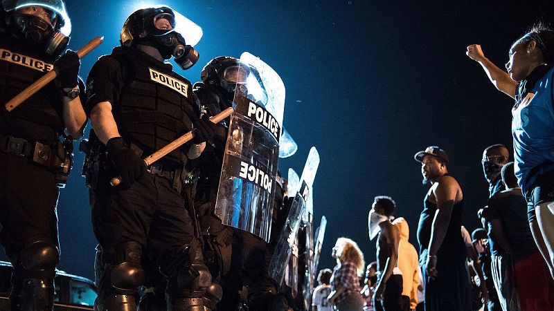 Antidisturbios y manifestantes frente a frente en una carretera en Charlotte. Una persona ha resultado herida de bala durante los disturbios. El disparo ha sido efectuado por otro civil.