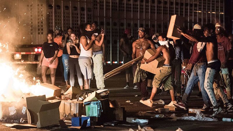 Los manifestantes alimentan una hoguera para exigir que se aclare la muerte de Keith Lamont Scott. La Policía asegura que el hombre abatido por sus agentes iba armado, pero la familia lo niega.