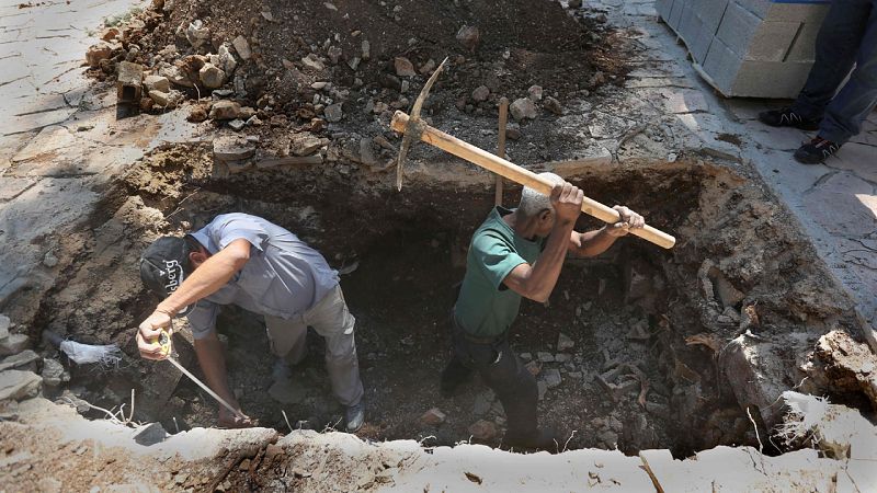 Obreros israelíes cavan la tumba de Simón Peres en el Monte Herzl de Jerusalén