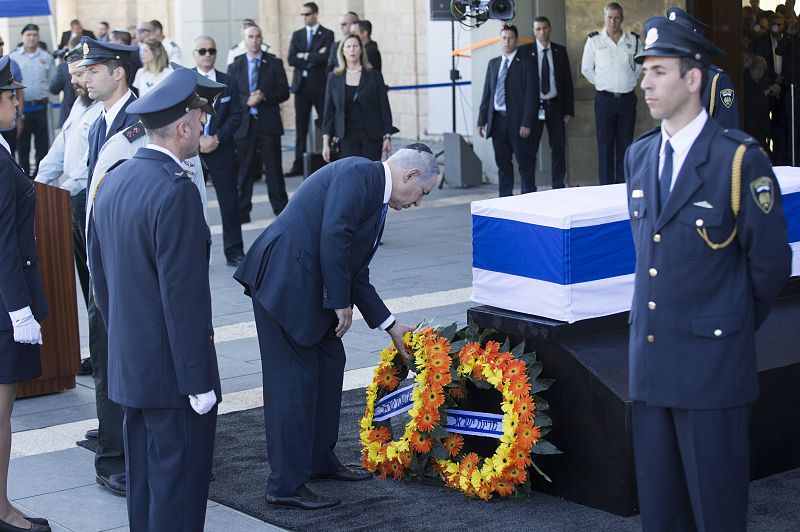 El primer ministro de Israel Benjamin Netanyahu (C) rinde sus respetos ante el féretro de Peres