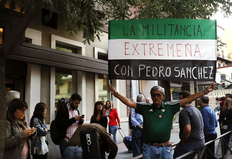 Un simpatizante del partido sostiene una pancarta a las puertas de la sede de la calle Ferraz.