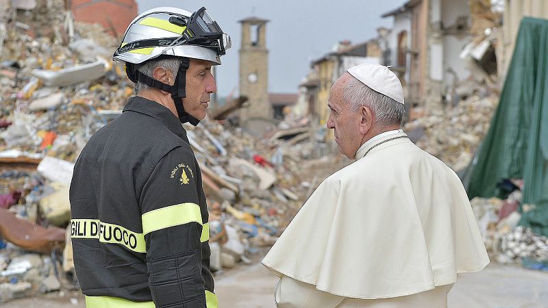 El papa Francsico habla con un bombero durante su visita a Amatrice, Italia, el 4 de octubre de 2016. Amatrice fue el pueblo más golpeado por el terremoto del 24 de agosto que mató a 300 personas. AFP PHOTO / OSSERVATORE ROMANO