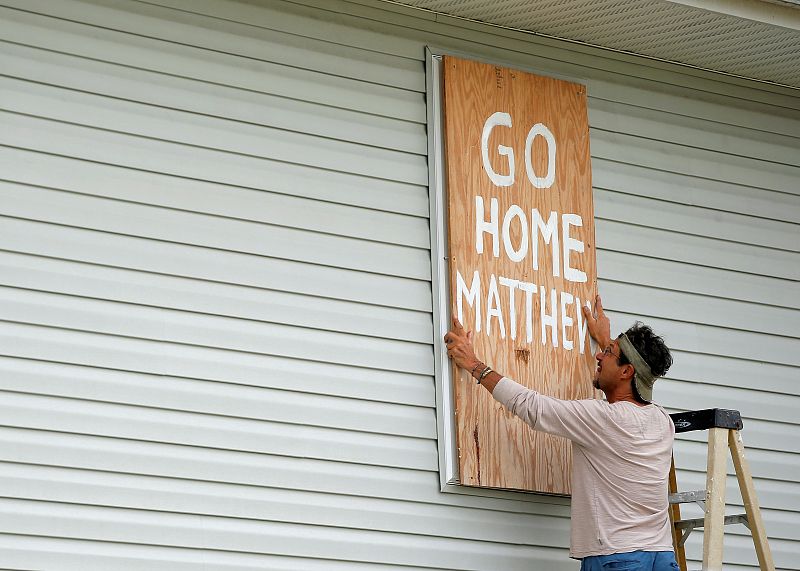 Homeowner Don Appell prepares to board up one of the windows at his home ahead of Hurricane Matthew in Cherry Grove