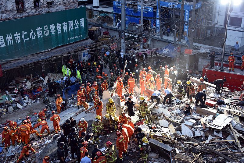 Los equipos de rescate buscan supervivientes entre los escombros de varios edificios de viviendas derrumbados en la ciudad china de Wenzhou.