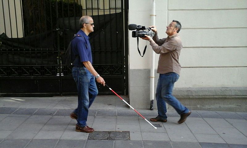 Carlos por la calle ayudado de su bastón rojo y blanco