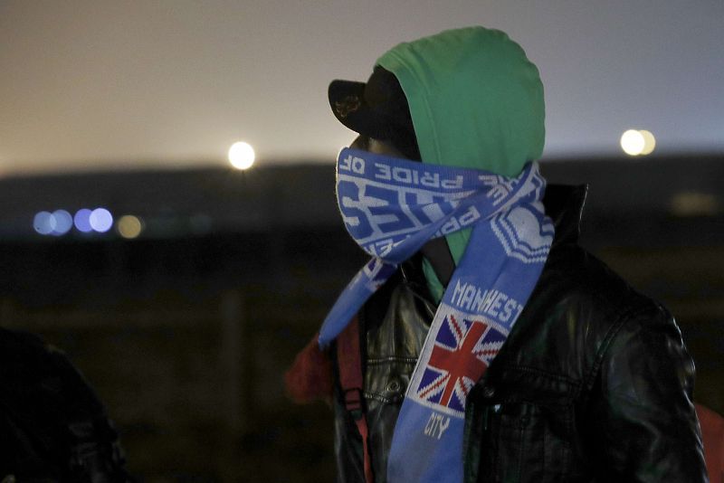 Un migrante con la bufanda de un equipo de fútbol británico en el campamento de "La Jungla" de Calais. El desalojo del campamento ilegal ha comenzado este lunes a las 8 de la mañana y podría alargarse durante una semana