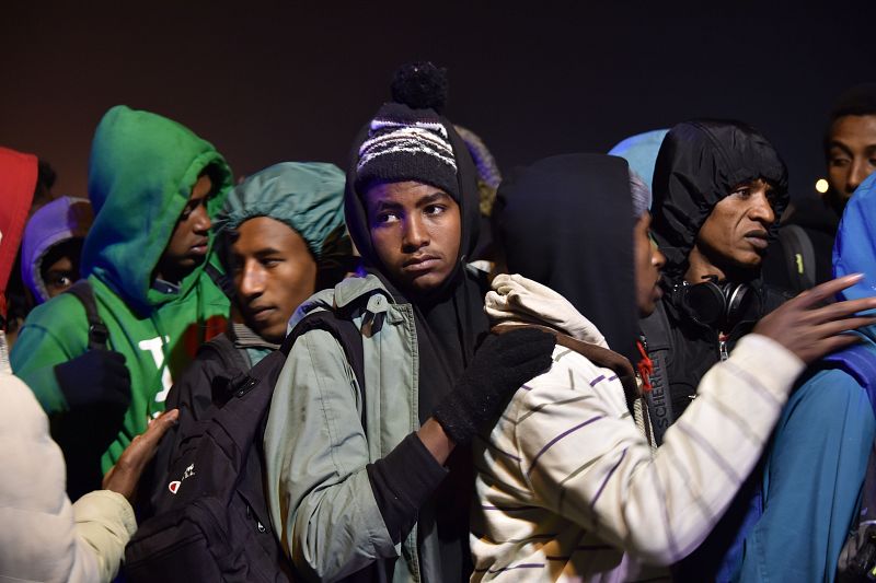 Migrantes esperando para ser desalojados del campamento de Calais