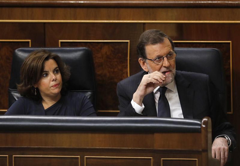 El presidente del Gobierno en funciones, Mariano Rajoy, acompañado por la vicepresidenta, Soraya Sáenz de Santamaría, escucha la intervención del portavoz del PSOE, Antonio Hernando.