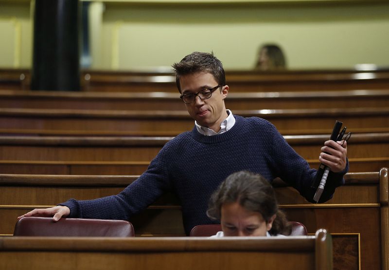 El portavoz de Podemos, Íñigo Errejón, llega a su escaño, junto al líder de la formación, Pablo Iglesias.