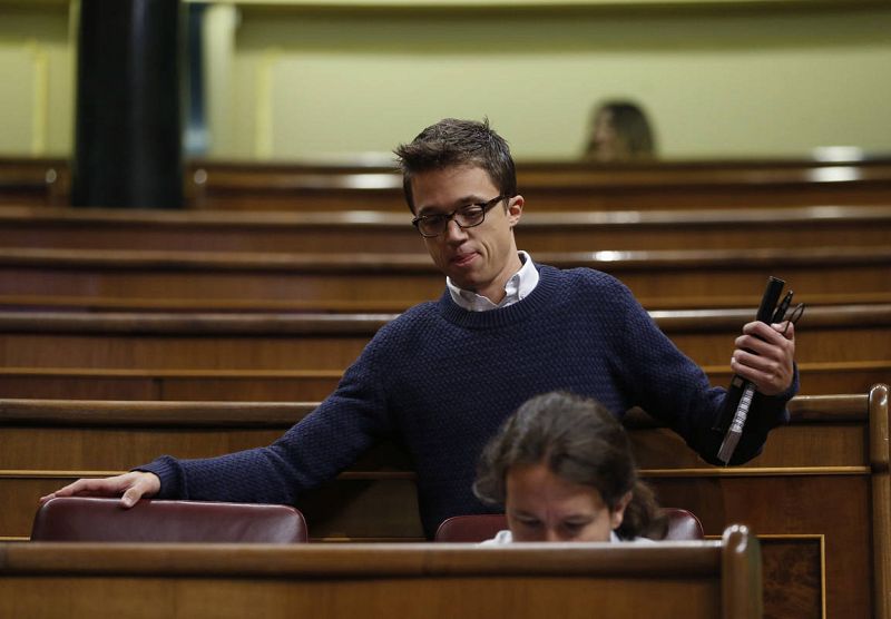 El portavoz de Podemos, Íñigo Errejón, llega a su escaño, junto al líder de la formación, Pablo Iglesias.