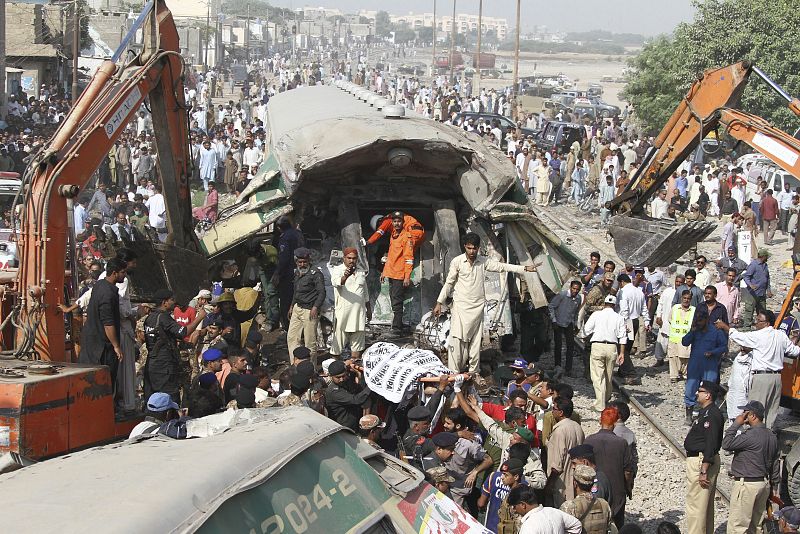 Miembros de los servicios de rescate trabajan para sacar a víctimas de un vagón de tren tras el choque de dos convoyes en Karachi, en el que han perdido la vida al menos 14 personas.