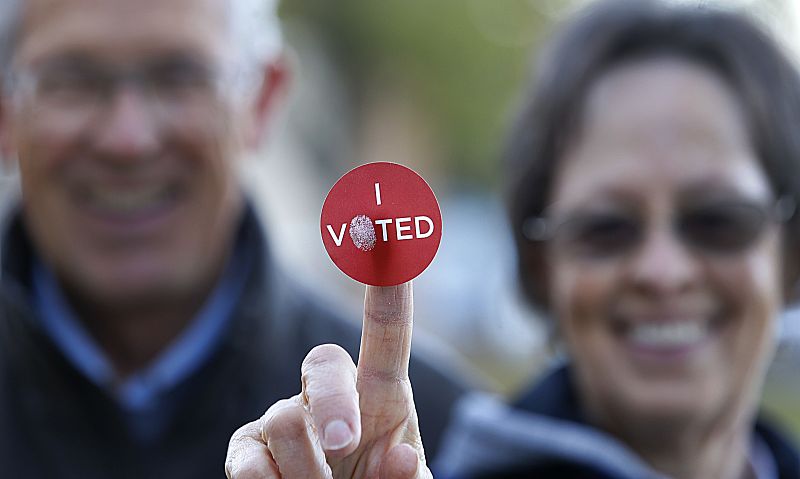 Una pareja muestra una pegatina en la que se puede leer "Voté", en Provo (Utah).