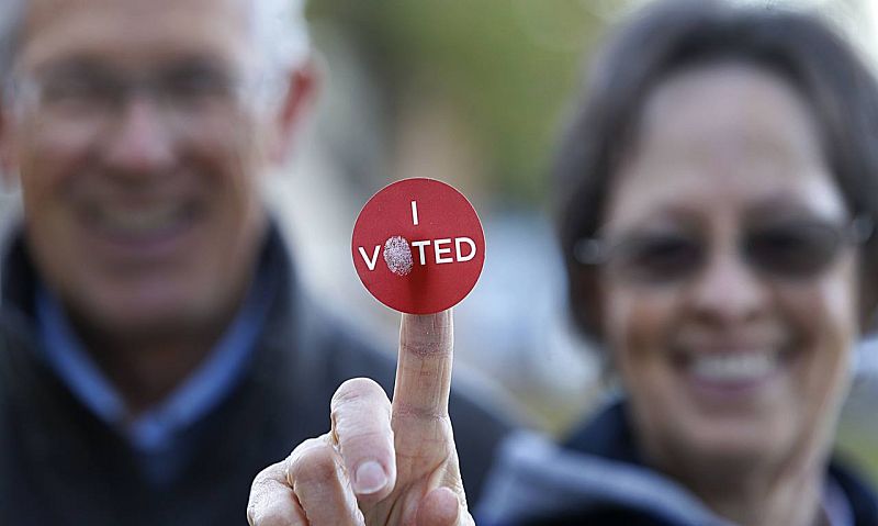 Una pareja muestra una pegatina en la que se puede leer "Voté", en Provo (Utah).