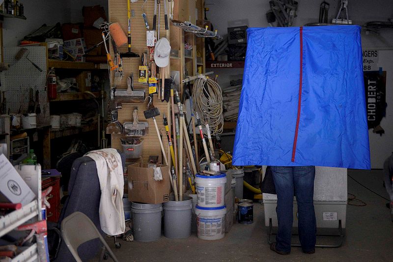 Un elector introduce su papeleta en una cabina ubicada en el garaje de unos almacenes de decoración, en Filadelfia, capital del estado de Pensilvania.