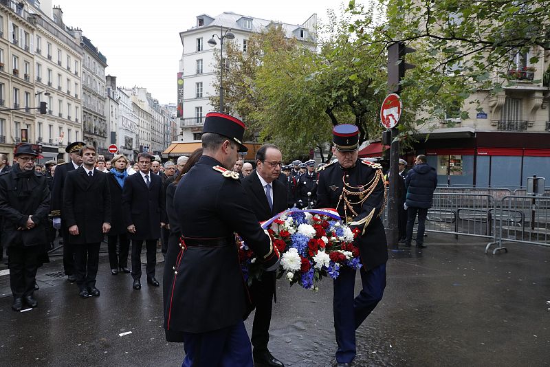 Hollande deposita flores junto a la placa conmemorativa en el café 'A La Bonne Biere', uno de los lugares atacados