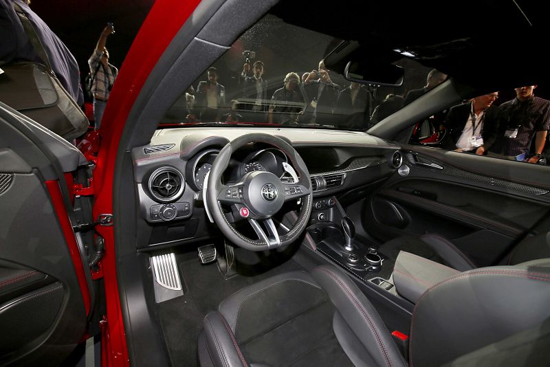 Varias personas miran el interior del 2018 Stelvio SUV