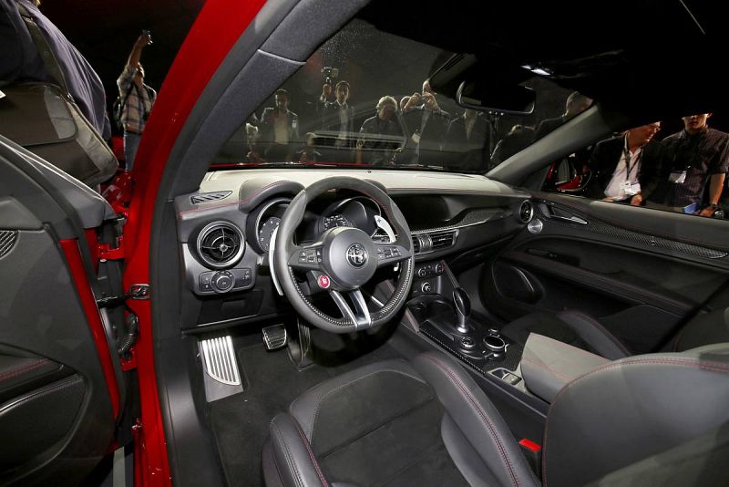 Varias personas miran el interior del 2018 Stelvio SUV