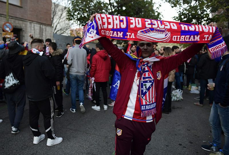 Un aficionado muestra su bufanda del Atlético de Madrid.