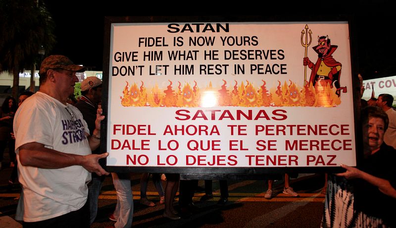 Un exiliado cubano muestra un cartel en las calles de Miami.