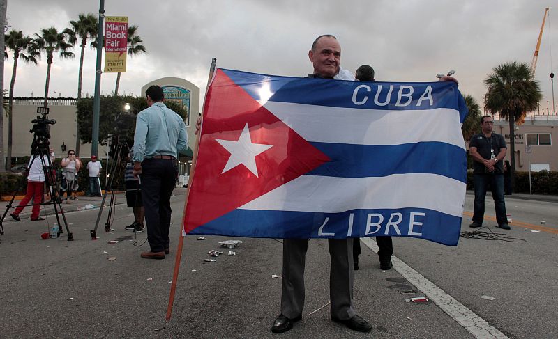 Un hombre muestra una bandera con el lema Cuba Libre.