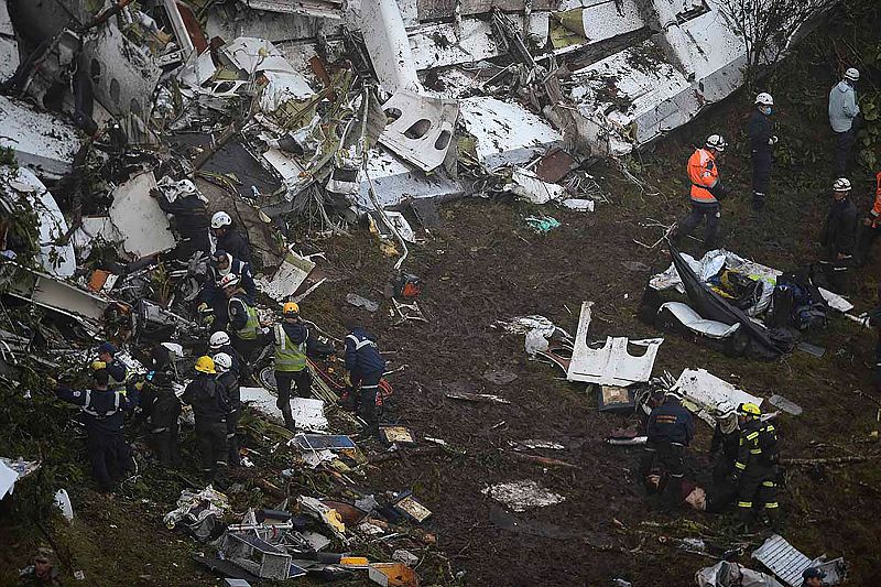 Miembros de los equipos de rescate inspeccionan el fuselaje del avión de LAMIA siniestrado en Colombia.