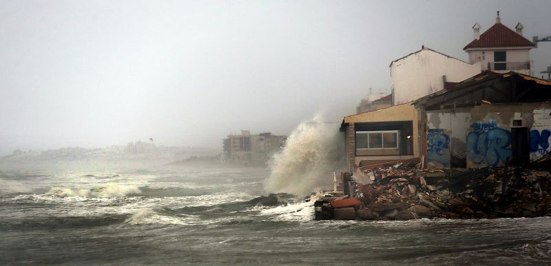 Las olas rompen sobre una casa junto a la playa en Guardamar del Segura (Alicante) por el temporal marítimo en la costa levantina.