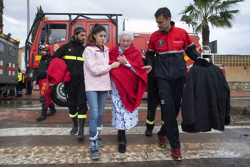 Varios militares de la Unidad Militar de Emergencia (UME) trasladan a una mujer que ha sido rescatada de su casa inundada tras las intensas lluvias caídas la pasada noche en Los Alcazares, Murcia.