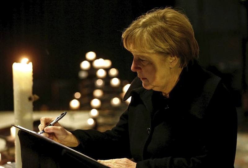 La canciller alemana, Angela Merkel, firma en el libro de condolencias de la Iglesia Memorial Kaiser Wilhelm en Berlín.