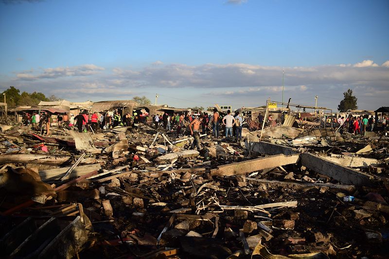 Vecinos buscan entre los escombros que ha dejado la explosión del mercado de pirotecnia en Tultepec. Hay ya al menos 36 muertos y decenas de heridos.