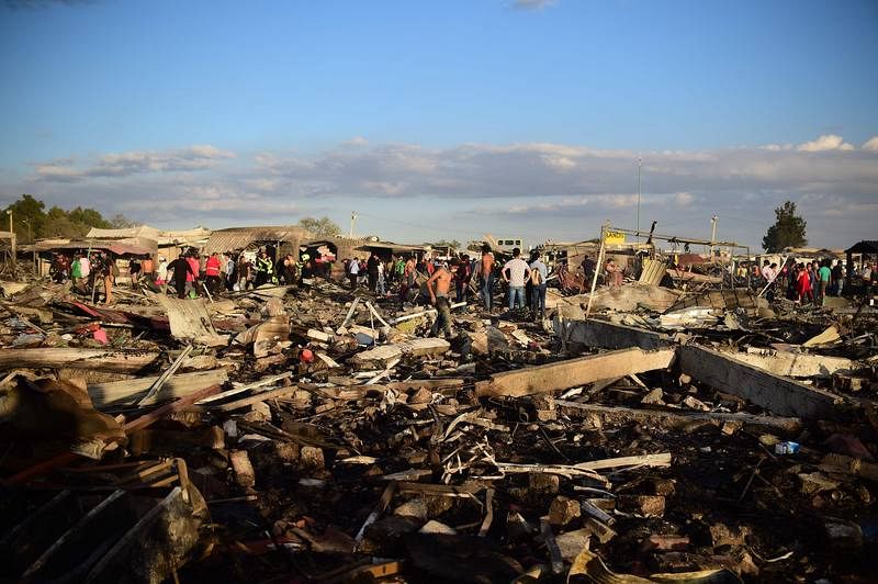 Vecinos buscan entre los escombros que ha dejado la explosión del mercado de pirotecnia en Tultepec. Hay ya al menos 36 muertos y decenas de heridos.