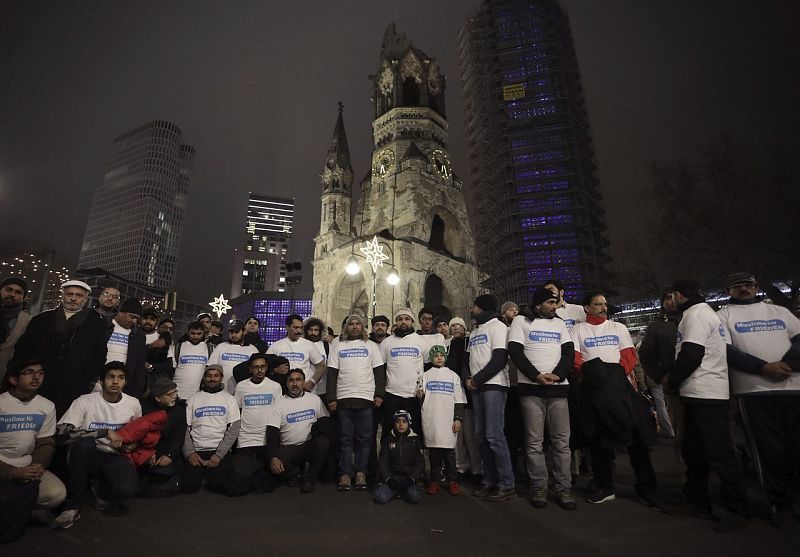 Varias personas con una camiseta en la que se puede leer 'Musulmanes por la Paz' en las inmediaciones de la Iglesia Memorial Kaiser Wilhelm donde se oficia la misa por las víctimas del atentado.