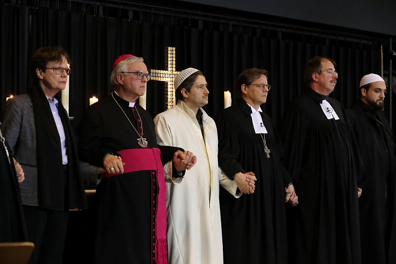 De izquierda a derecha, representantes de distintas religiones cogen sus manos durante el servicio religioso por las víctimas en la Iglesia del Kaiser Guillermo, en Berlín.