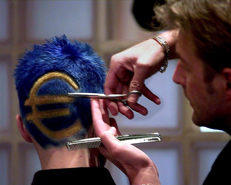 Un peluquero cortando el pelo y tintándolo con el logo del Euro, en Deinze, Bélgica, en diciembre de 2001.