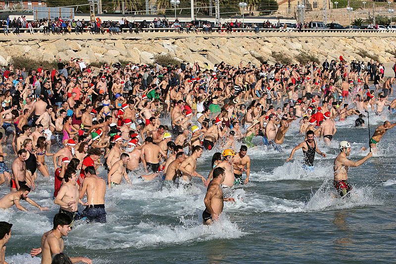 Cientos de personas se zambullen en el agua en el tradicional Baño de San Silvestre que se ha celebrado este año en su 32ª edición en la playa de La Comanadancia de Tarragona.