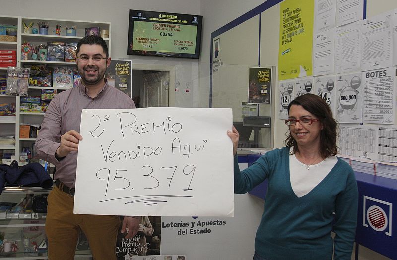 Los dueños de la Administración de la calle Concheiros de Santiago muestran el número 95.379, vendido en este establecimiento y agraciado con el segundo premio del sorteo extraordinario de El Niño