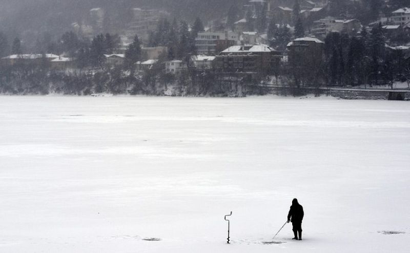 Un hombre pesca en un lago helado en Sofía, Bulgaría