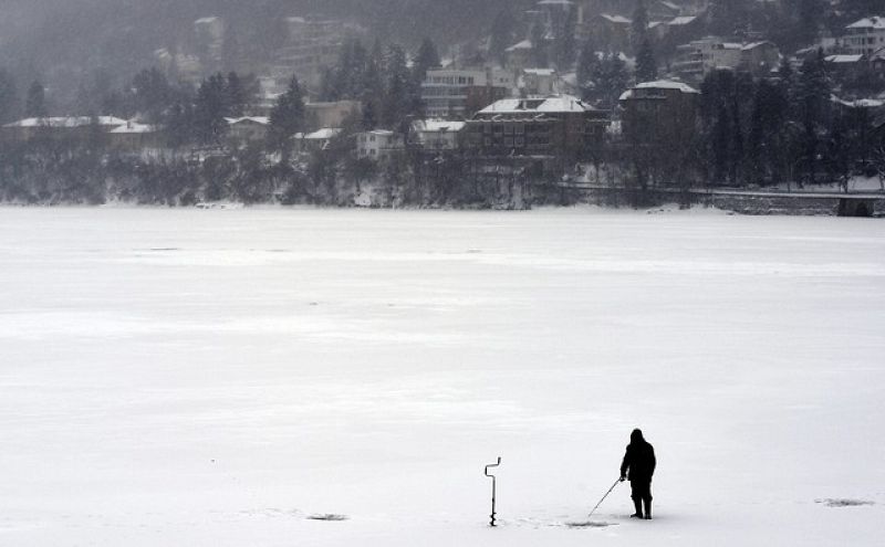 Un hombre pesca en un lago helado en Sofía, Bulgaría