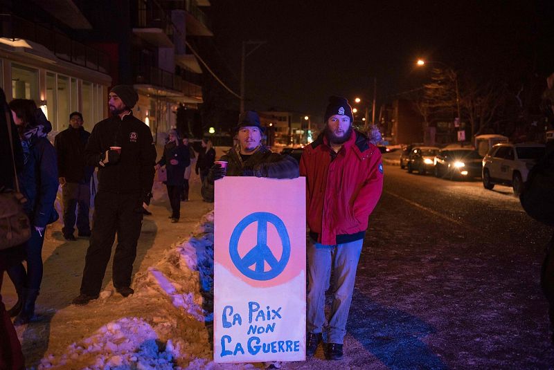 Vecinos con una pancarta en la que se lee, en francés, "Paz, no guerra", junto a la mezquita donde se ha producido el atentado.