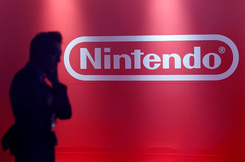 A man stands in front of Nintendo's logo at the presentation ceremony of its new game console Switch in Tokyo