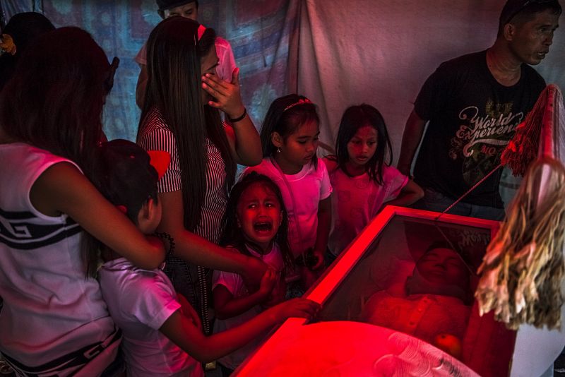 Esta fotofrafíacaptada por el fotógrafo Daniel Berehulak, de The New York Times titulada "They Are Slaughtering Us Like Animals", muestra a una niña de seis años que llora ante el féretro de su padre, Jimboy Bolasa, asesinado por varios hombres sin i