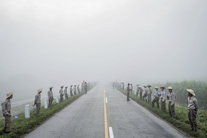 La imagen muestra a miembros del Ejercito Juvenil del Trabajo alineados en una carretera de Santiago de Cuba mientras aguardan la llegada de los restos mortales del líder cubano Fidel Castro en diciembre de 2016.