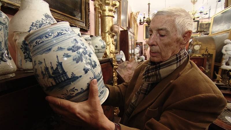 Tomas Pérez en su tienda con una cerámica de Talavera