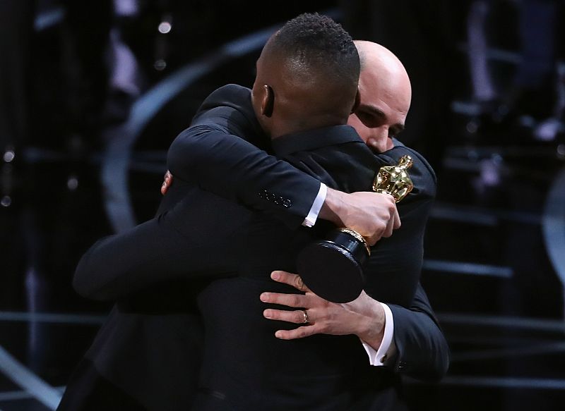 Jordan Horowitz abraza al director de 'Moonlight', Barry Jenkins, y le entrega el Oscar a mejor película de 2017