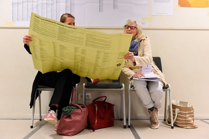 Dos electoras consultan las candidaturas en La Haya.