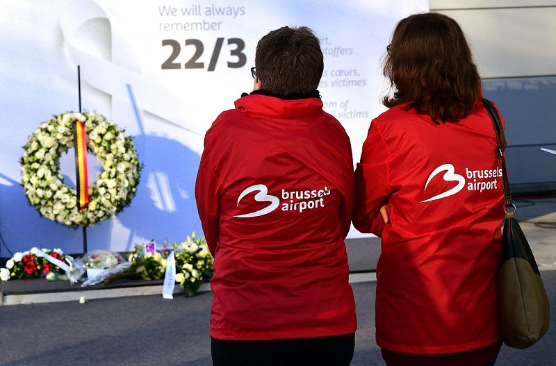 Empleadas del aeropuerto miran el memorial instalado en Zaventem.