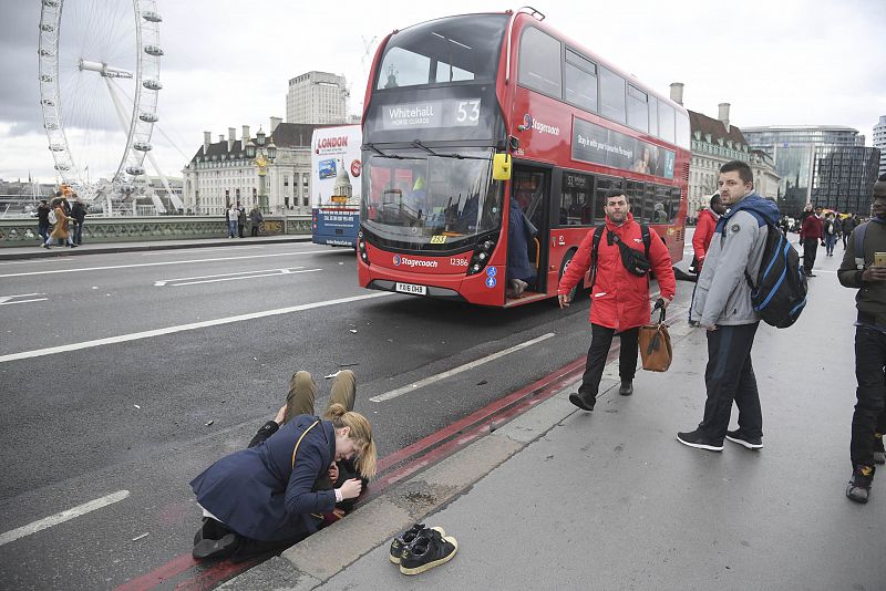 Una mujer asiste a una persona herida en el puente de Westminster